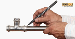 An individual writes on a metal pipe, blending artistry with industrial materials.